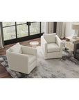 Modern living room with white armchairs, a gray sofa, and a small table.
