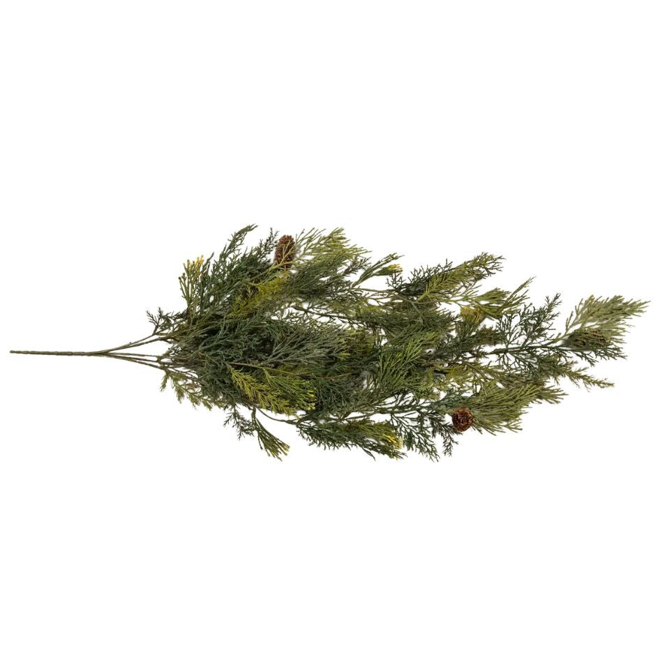 A single artificial evergreen branch with dense green needle-like foliage and small brown pinecones, photographed on a plain white background.